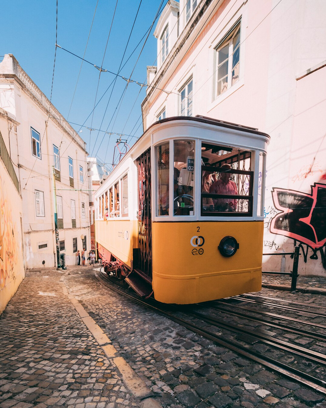 Yellow tram on a hilly street in Lisbon Portugal