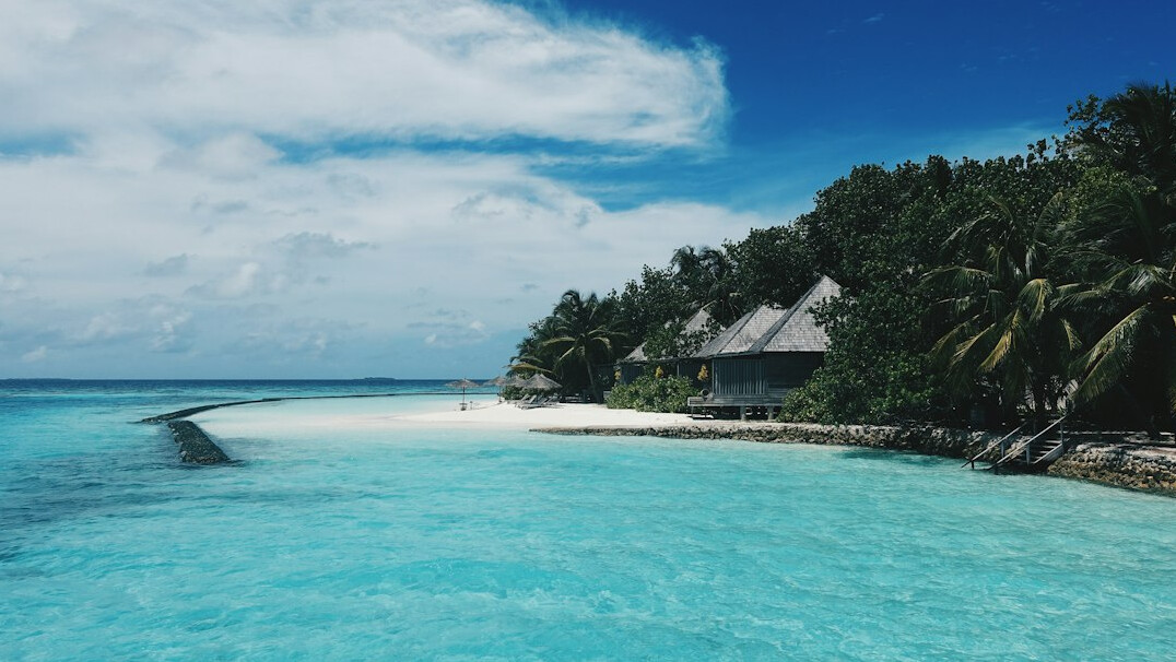 Overwater bungalows over a turquoise lagoon in the Maldives