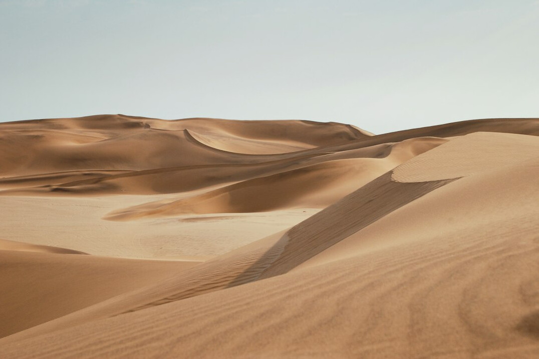Golden desert dunes under a clear sky